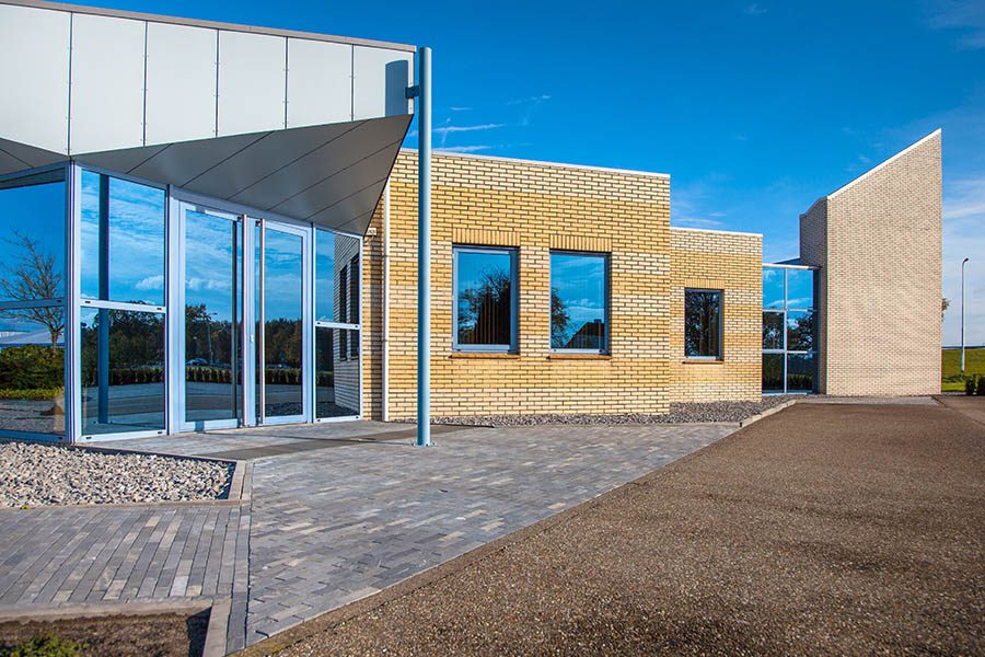 Business Insurance - Modern Glass and Brick Commercial Building With Brick and Gravel Floors on a Sunny Day